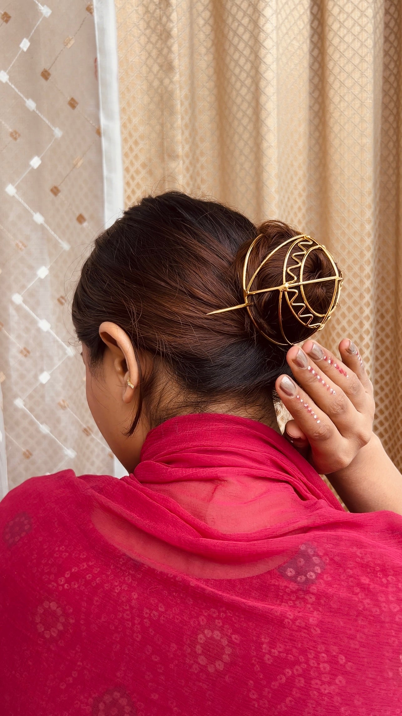 Gold spiral hairbun with concentric circles and intricate design. Elegant and artistic, it conveys a sense of sophistication.