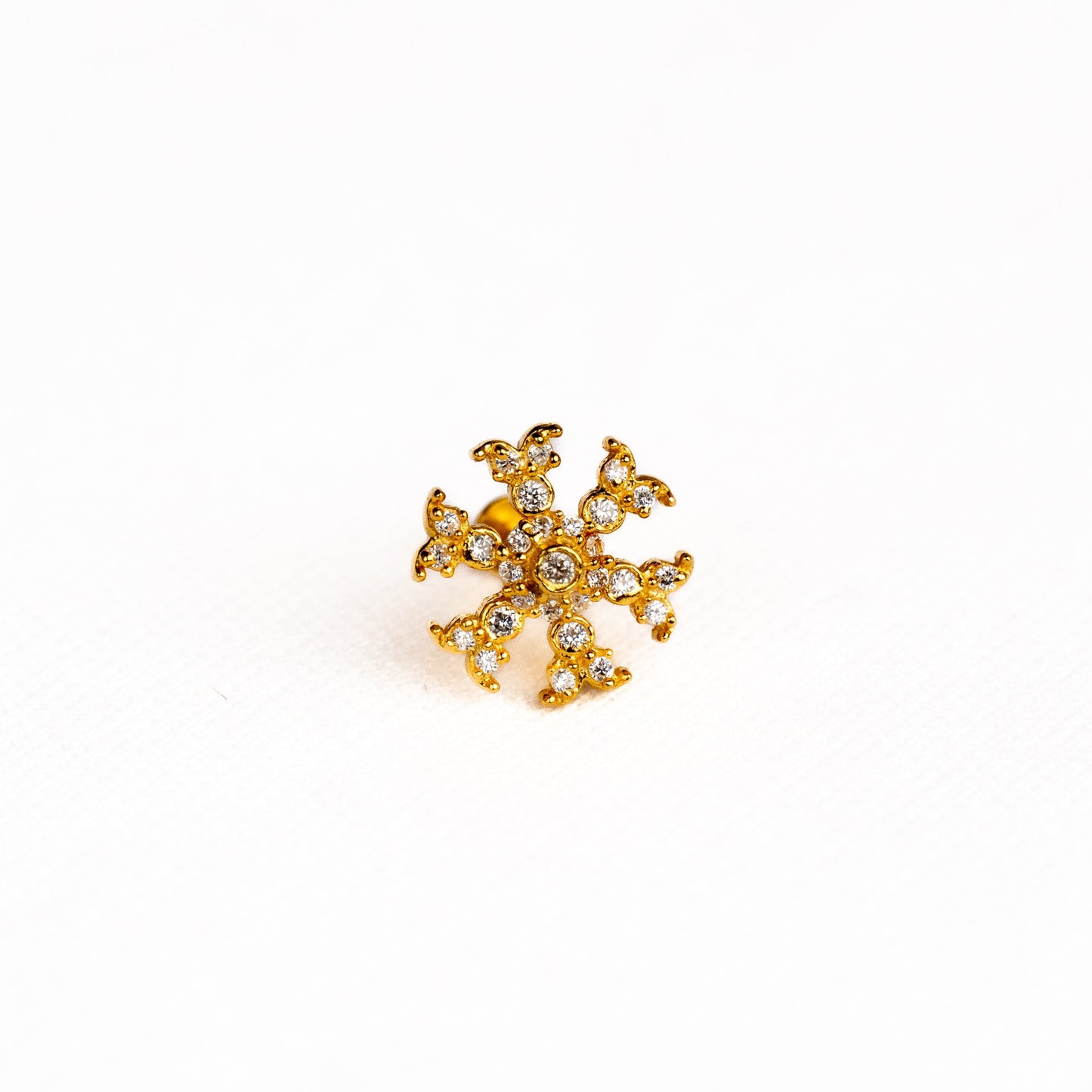 Silver nosepins featuring traditional motifs with a modern design twist, displayed on a neutral background.