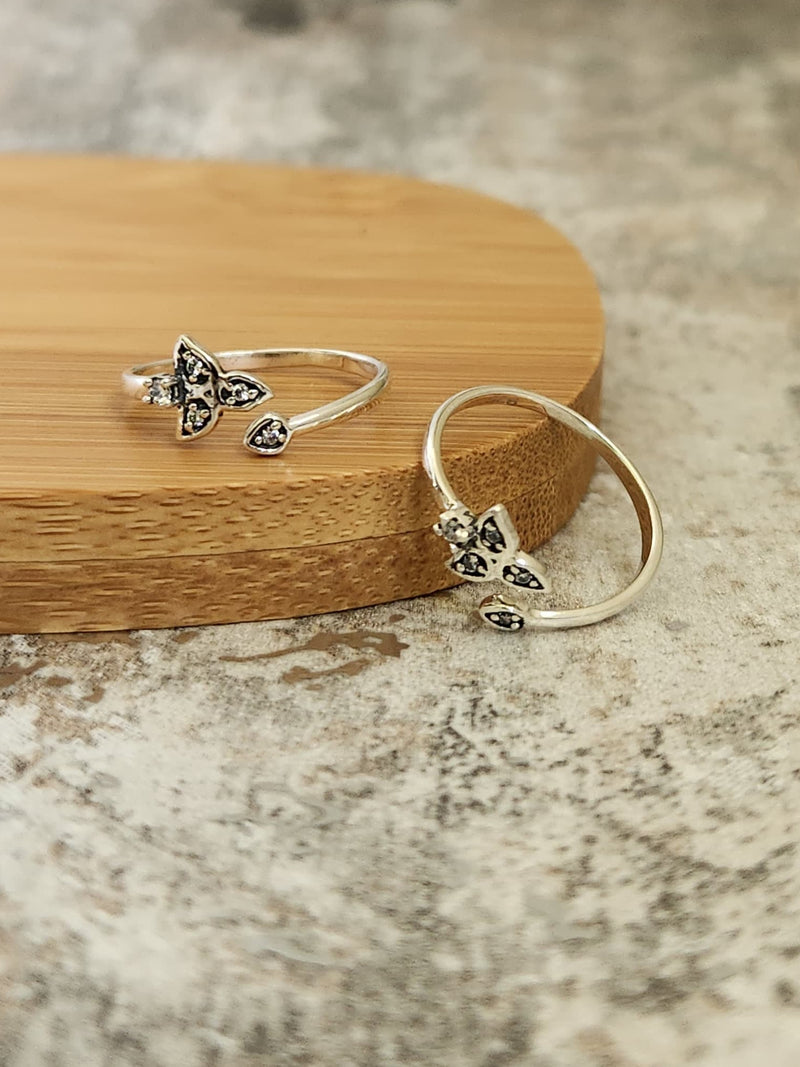 A pair of elegant silver toe rings with a polished finish, featuring delicate designs and an adjustable open band.