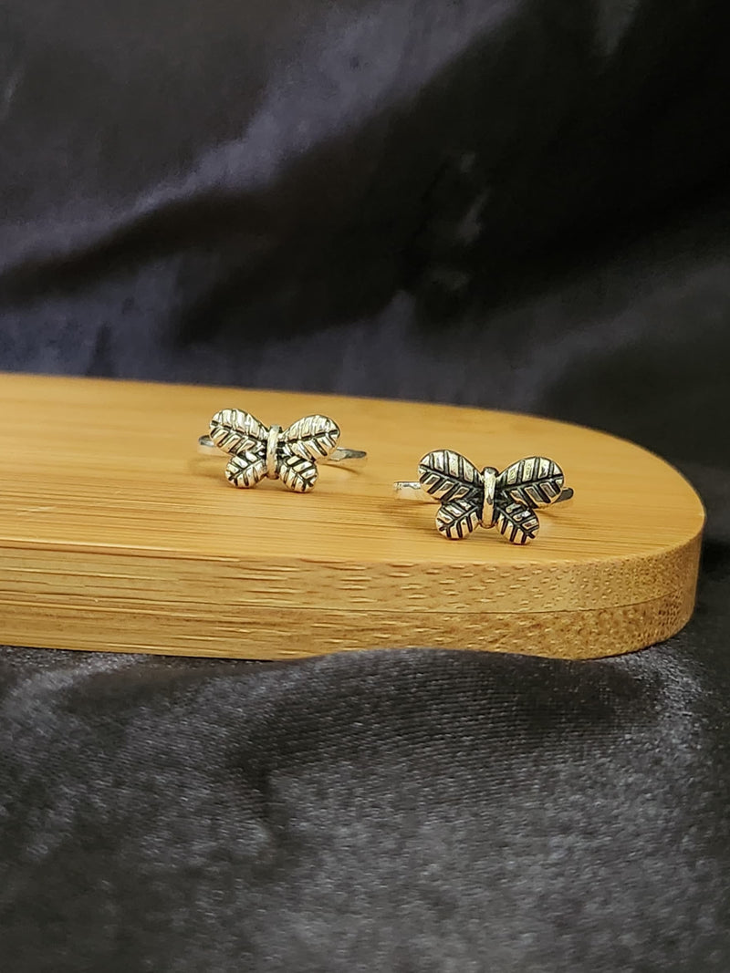 A pair of elegant silver toe rings with a polished finish, featuring delicate designs and an adjustable open band.
