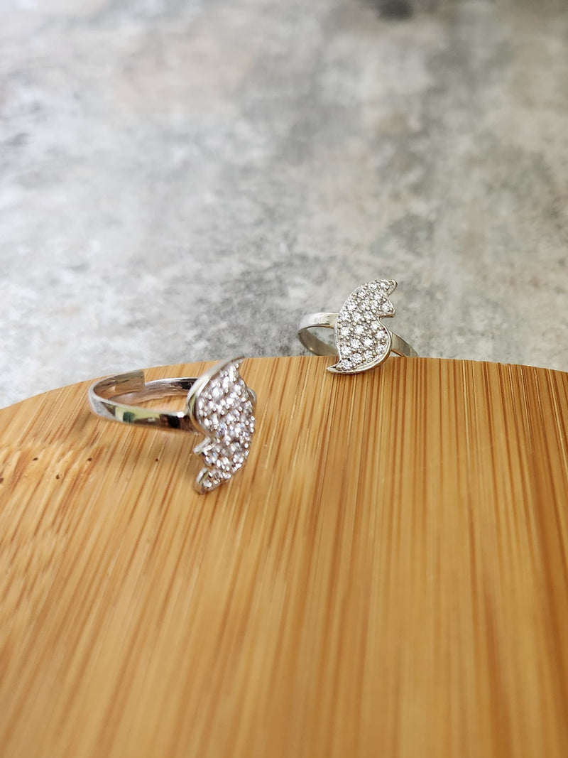 A pair of elegant silver toe rings with a polished finish, featuring delicate designs and an adjustable open band.