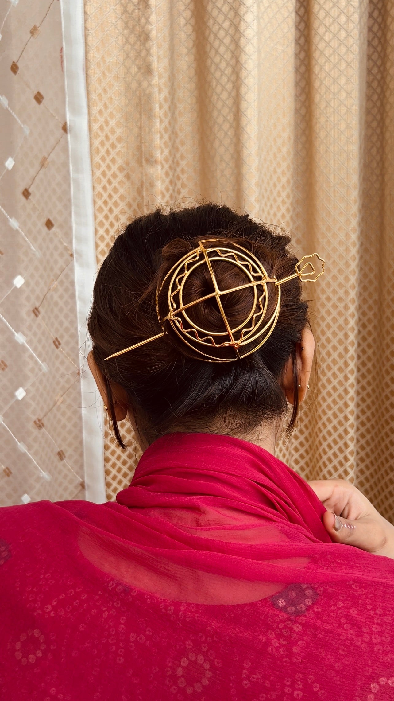 Gold spiral hairbun with concentric circles and intricate design. Elegant and artistic, it conveys a sense of sophistication.