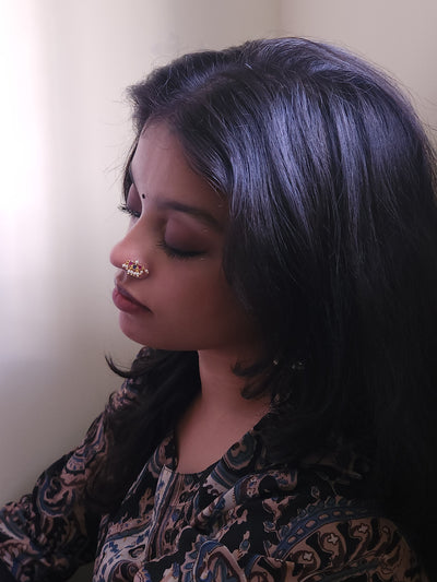 Silver nosepins featuring traditional motifs with a modern design twist, displayed on a neutral background.