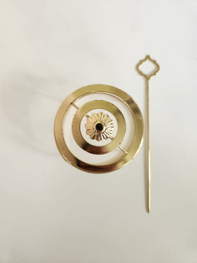 Gold spiral hairbun with concentric circles and intricate design. Elegant and artistic, it conveys a sense of sophistication.