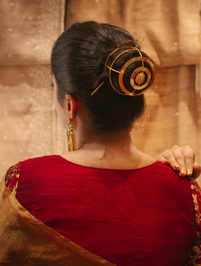 Gold spiral hairbun with concentric circles and intricate design. Elegant and artistic, it conveys a sense of sophistication.