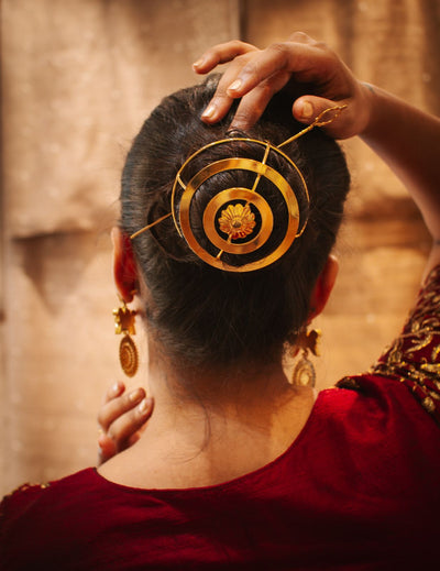 Gold spiral hairbun with concentric circles and intricate design. Elegant and artistic, it conveys a sense of sophistication.