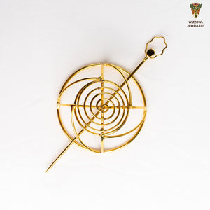 Gold spiral hairbun with concentric circles and intricate design. Elegant and artistic, it conveys a sense of sophistication.