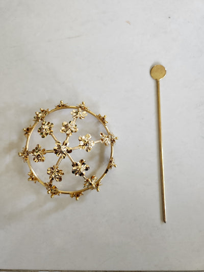Gold spiral hairbun with concentric circles and intricate design. Elegant and artistic, it conveys a sense of sophistication.