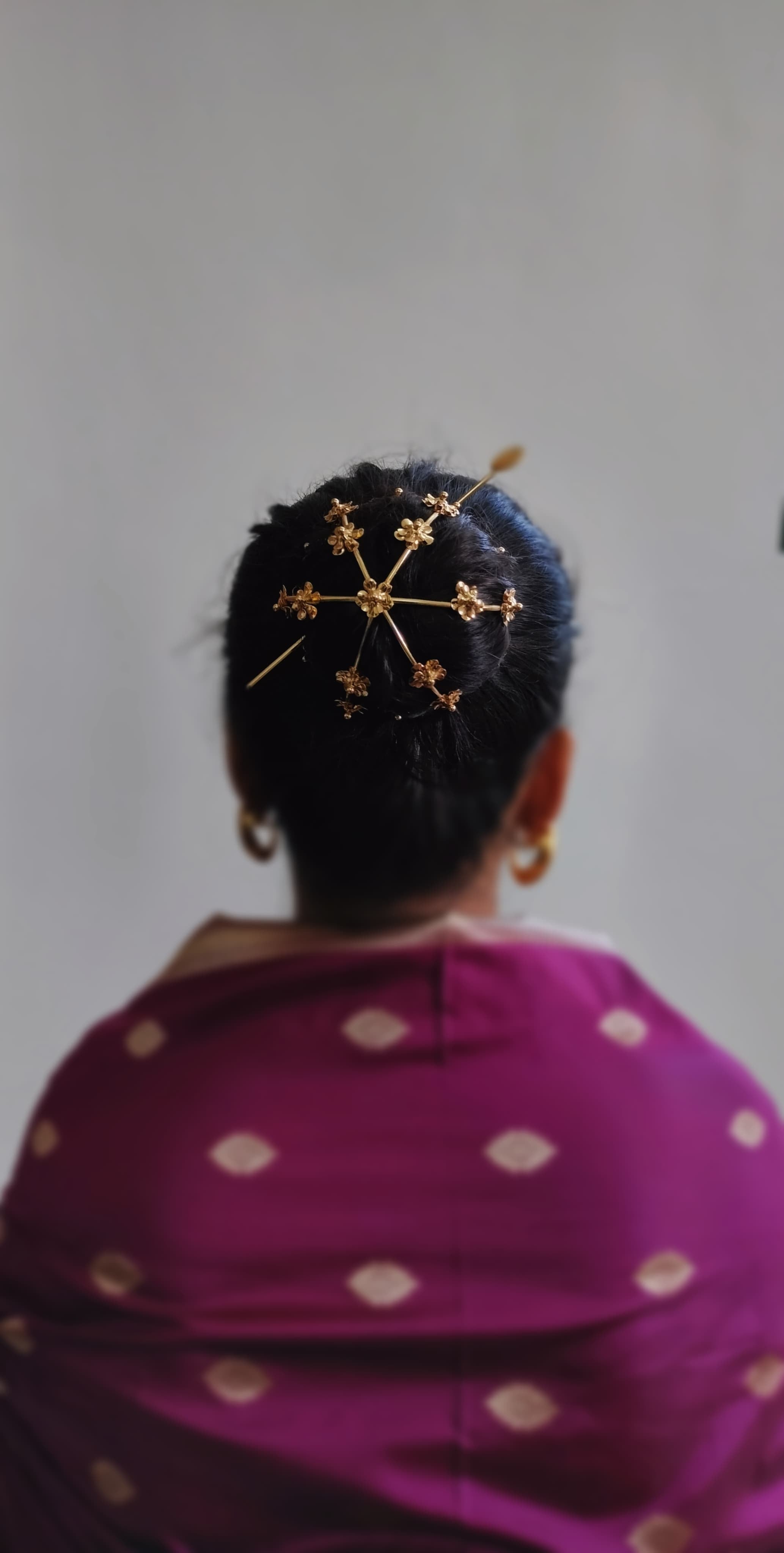 Gold spiral hairbun with concentric circles and intricate design. Elegant and artistic, it conveys a sense of sophistication.