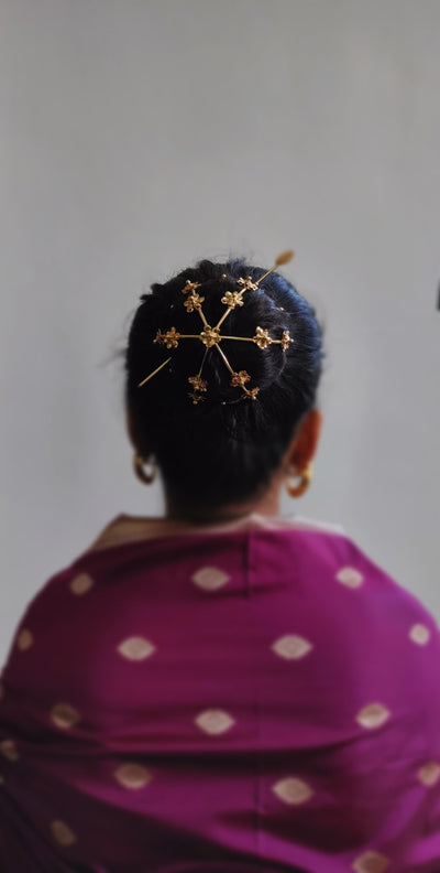 Gold spiral hairbun with concentric circles and intricate design. Elegant and artistic, it conveys a sense of sophistication.