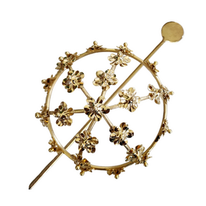Gold spiral hairbun with concentric circles and intricate design. Elegant and artistic, it conveys a sense of sophistication.