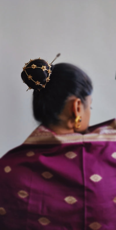 Gold spiral hairbun with concentric circles and intricate design. Elegant and artistic, it conveys a sense of sophistication.