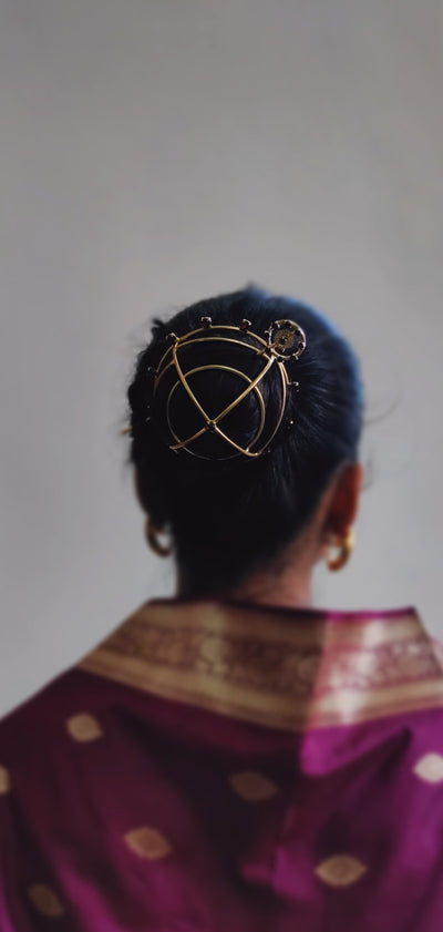 Gold spiral hairbun with concentric circles and intricate design. Elegant and artistic, it conveys a sense of sophistication.