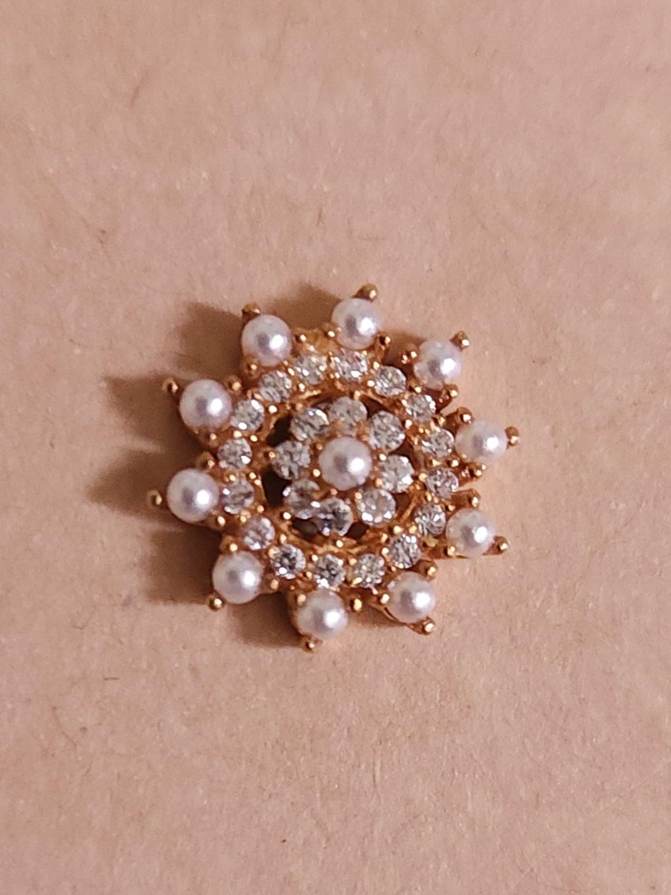 Silver nosepins featuring traditional motifs with a modern design twist, displayed on a neutral background.