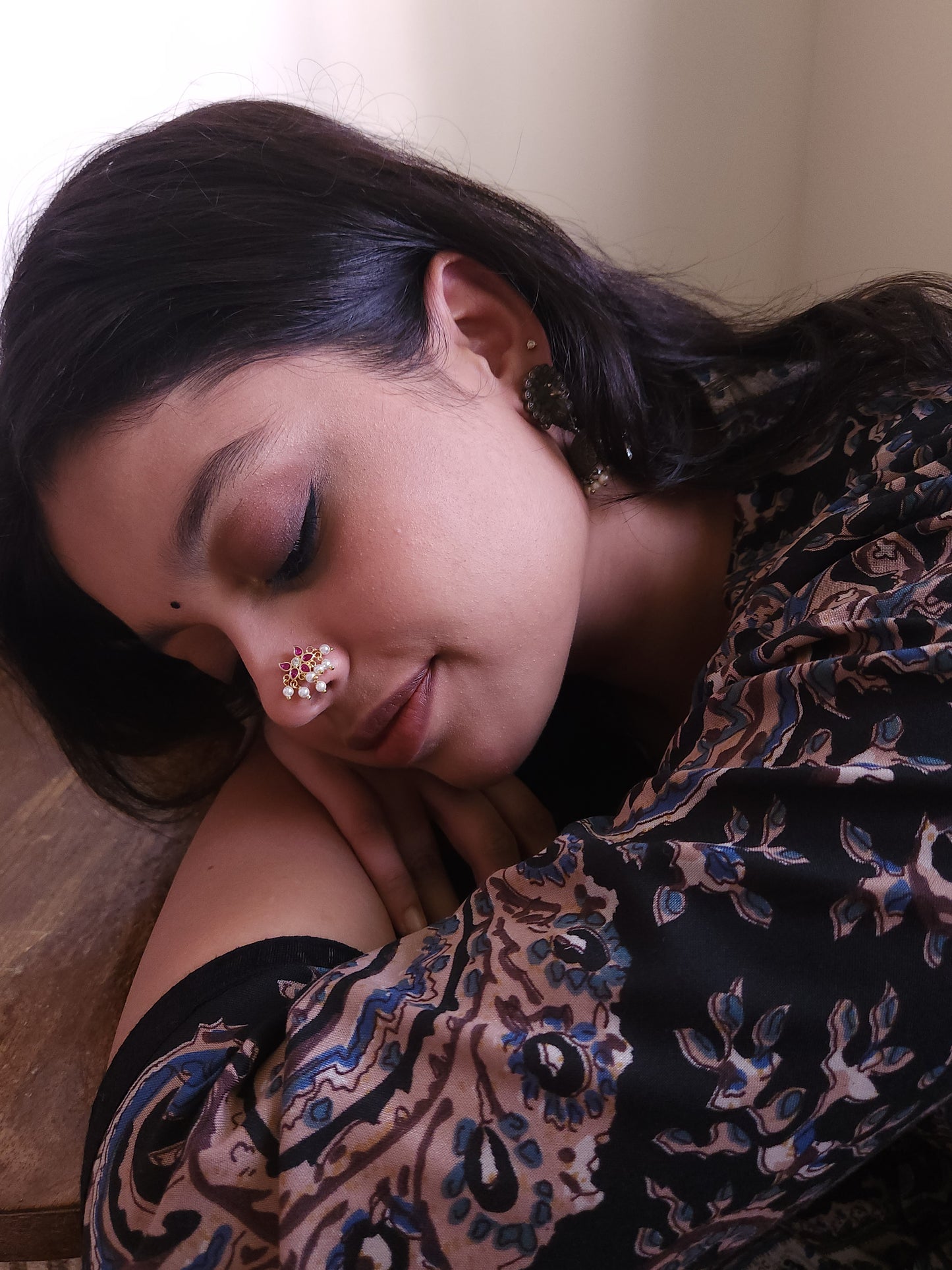 Silver nosepins featuring traditional motifs with a modern design twist, displayed on a neutral background.