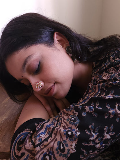 Silver nosepins featuring traditional motifs with a modern design twist, displayed on a neutral background.