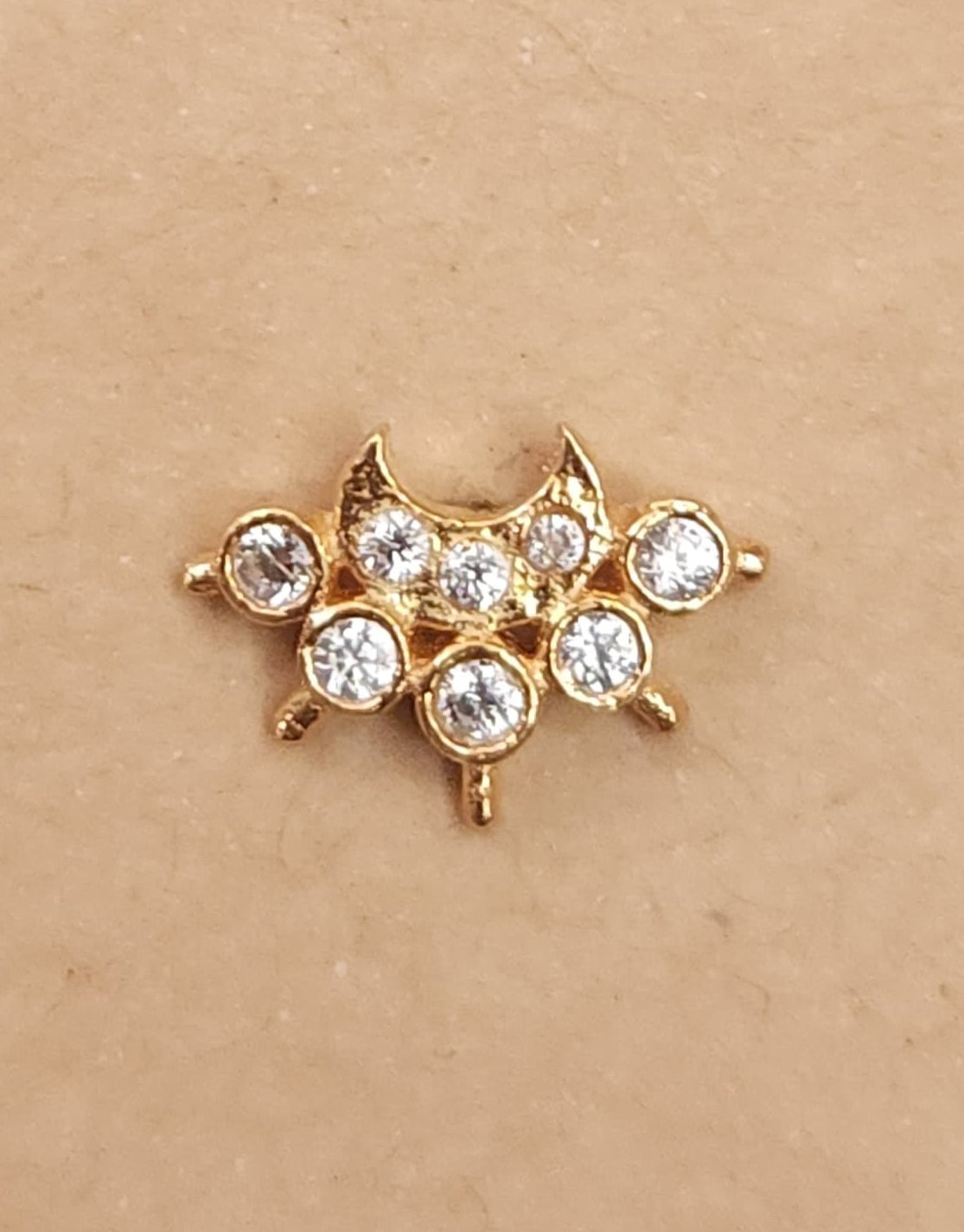 Silver nosepins featuring traditional motifs with a modern design twist, displayed on a neutral background.