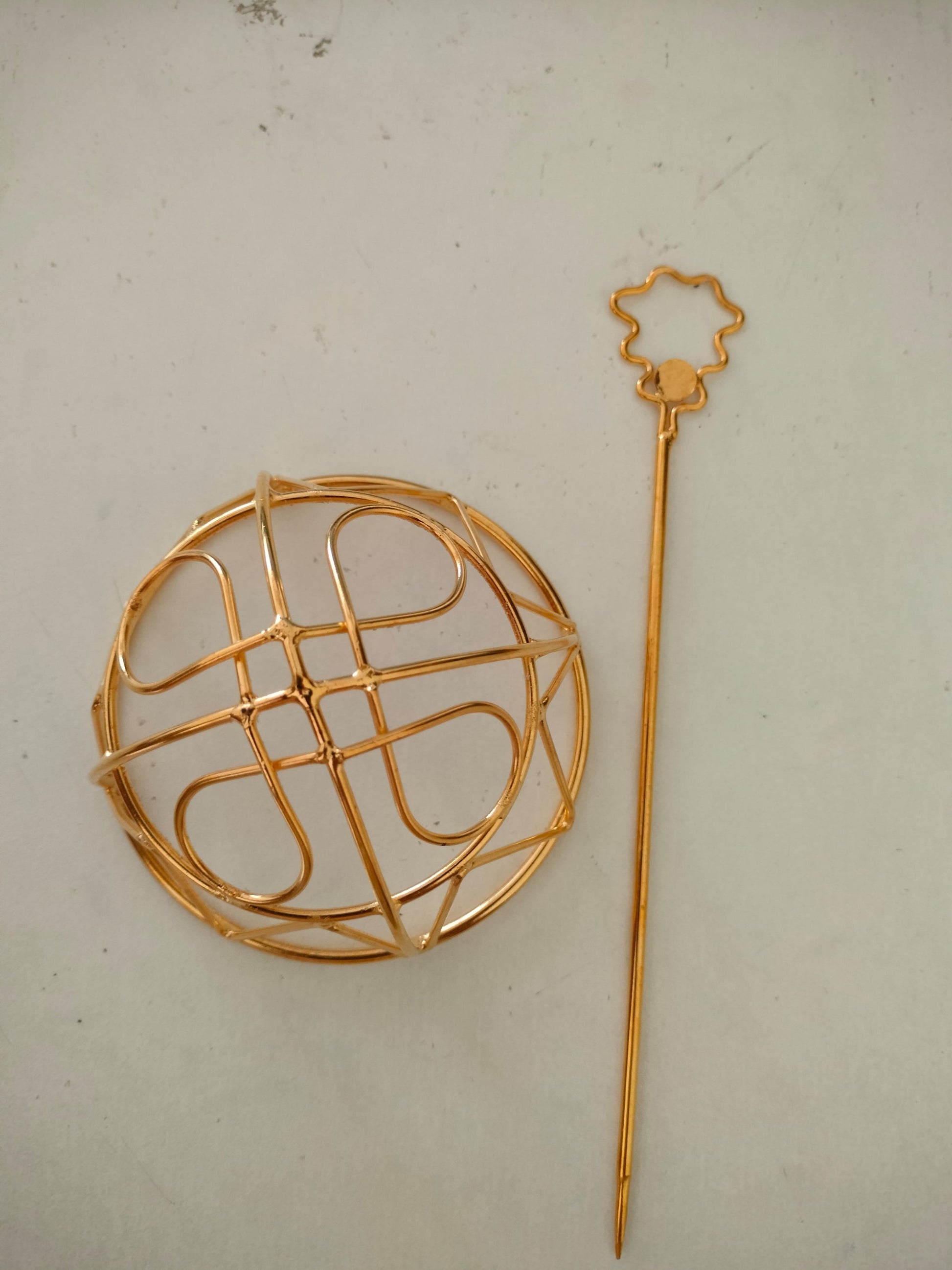 Gold spiral hairbun with concentric circles and intricate design. Elegant and artistic, it conveys a sense of sophistication.
