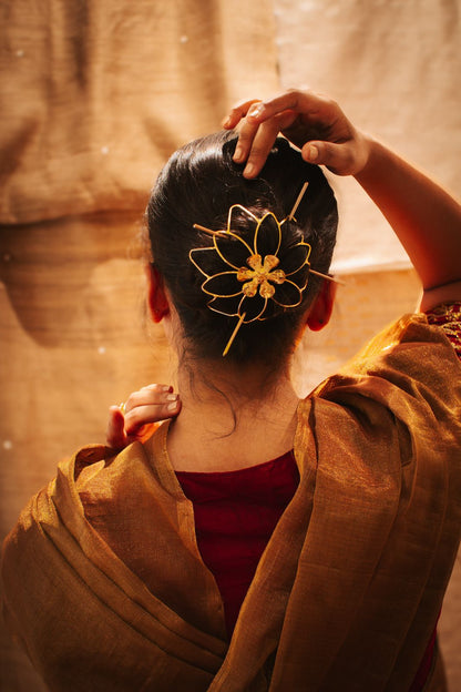 Gold spiral hairbun with concentric circles and intricate design. Elegant and artistic, it conveys a sense of sophistication.