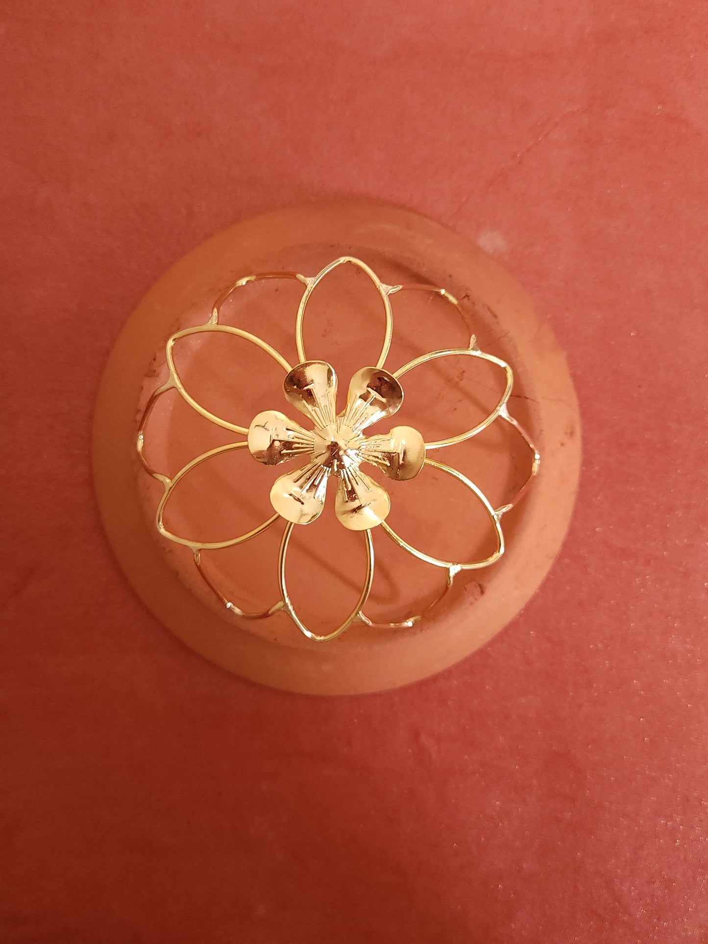 Gold spiral hairbun with concentric circles and intricate design. Elegant and artistic, it conveys a sense of sophistication.