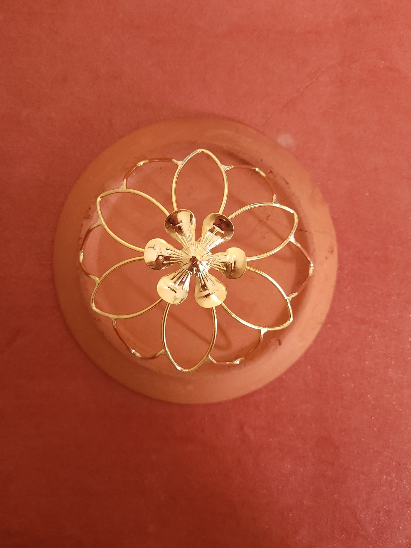 Gold spiral hairbun with concentric circles and intricate design. Elegant and artistic, it conveys a sense of sophistication.
