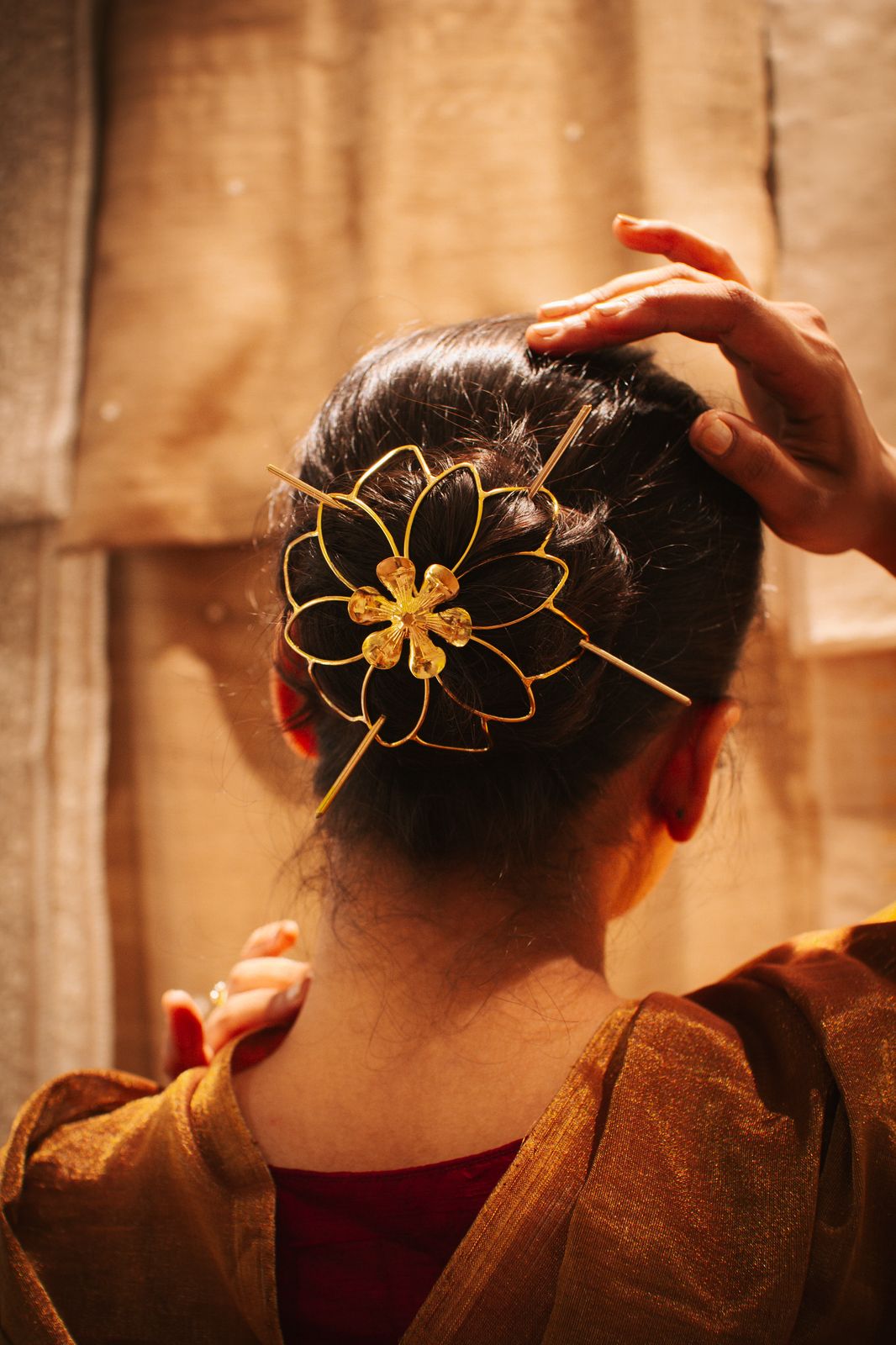 Gold spiral hairbun with concentric circles and intricate design. Elegant and artistic, it conveys a sense of sophistication.