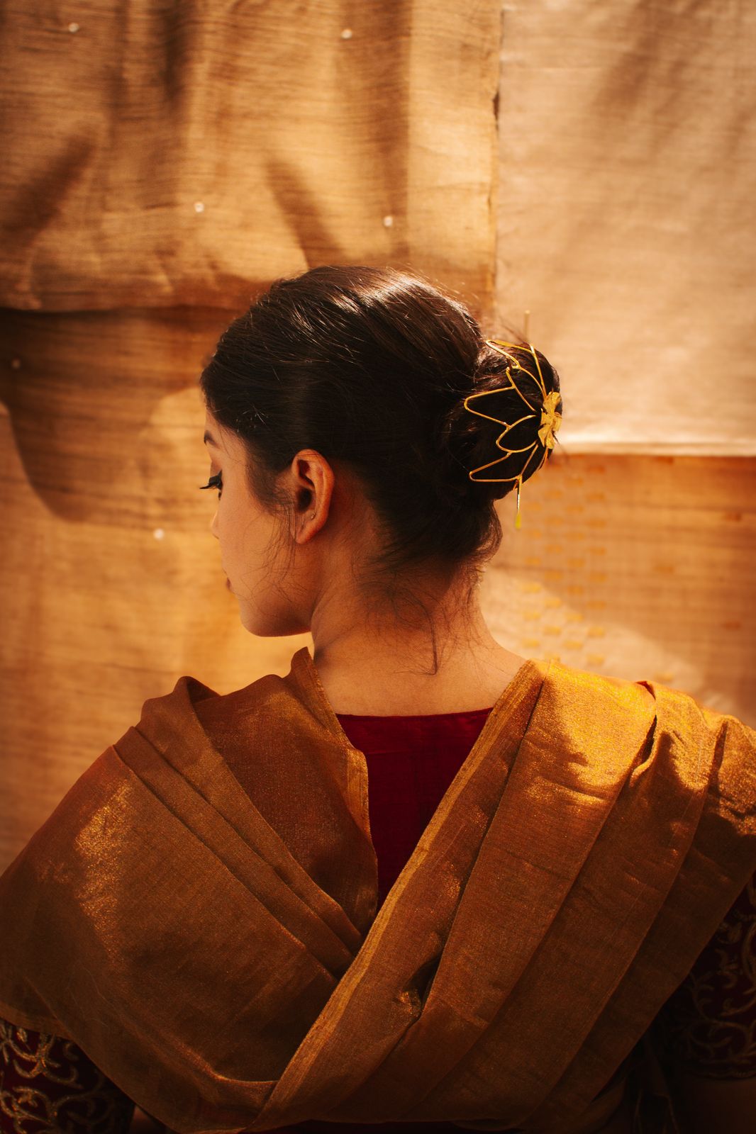Gold spiral hairbun with concentric circles and intricate design. Elegant and artistic, it conveys a sense of sophistication.