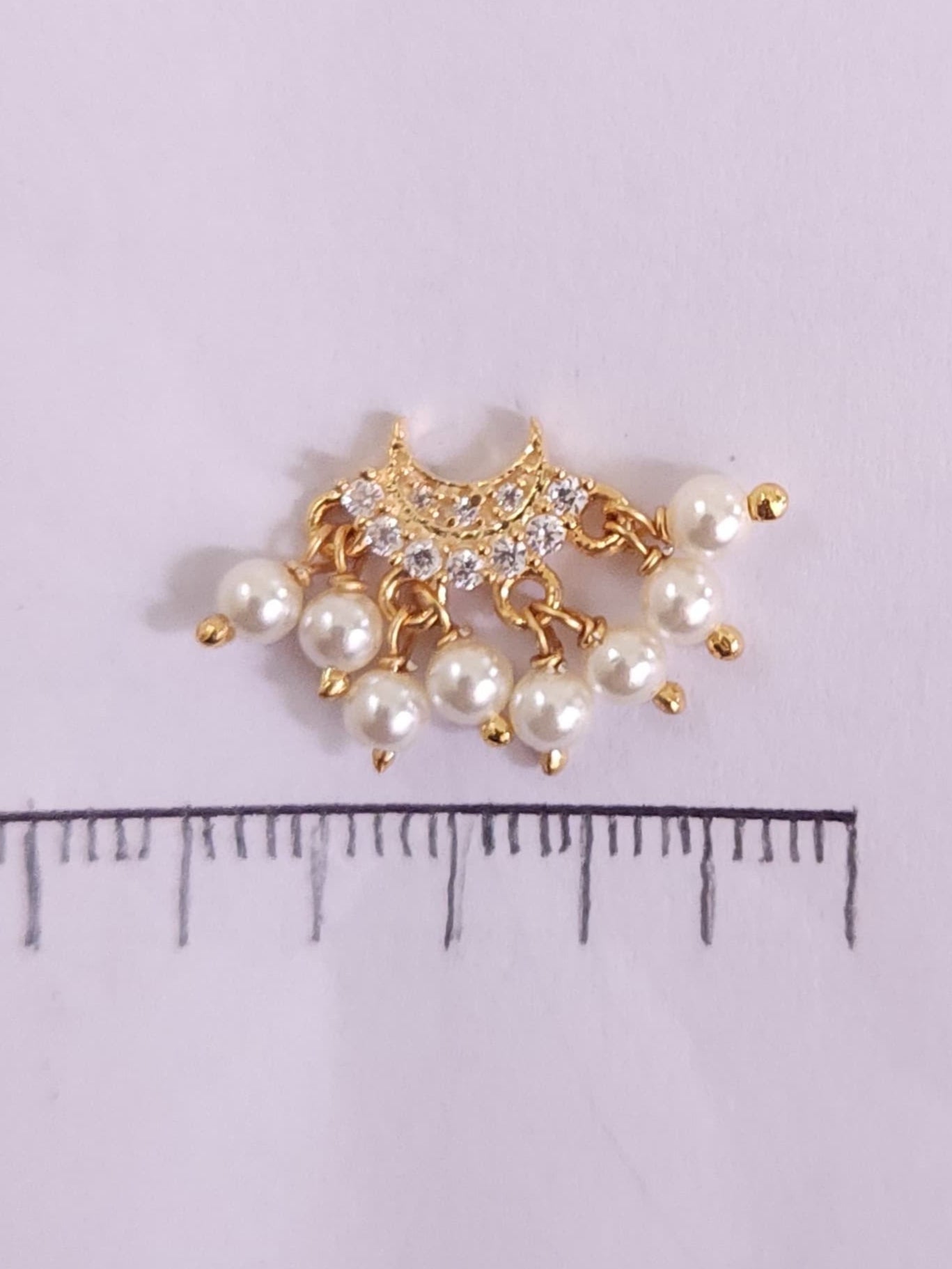 Silver nosepins featuring traditional motifs with a modern design twist, displayed on a neutral background.