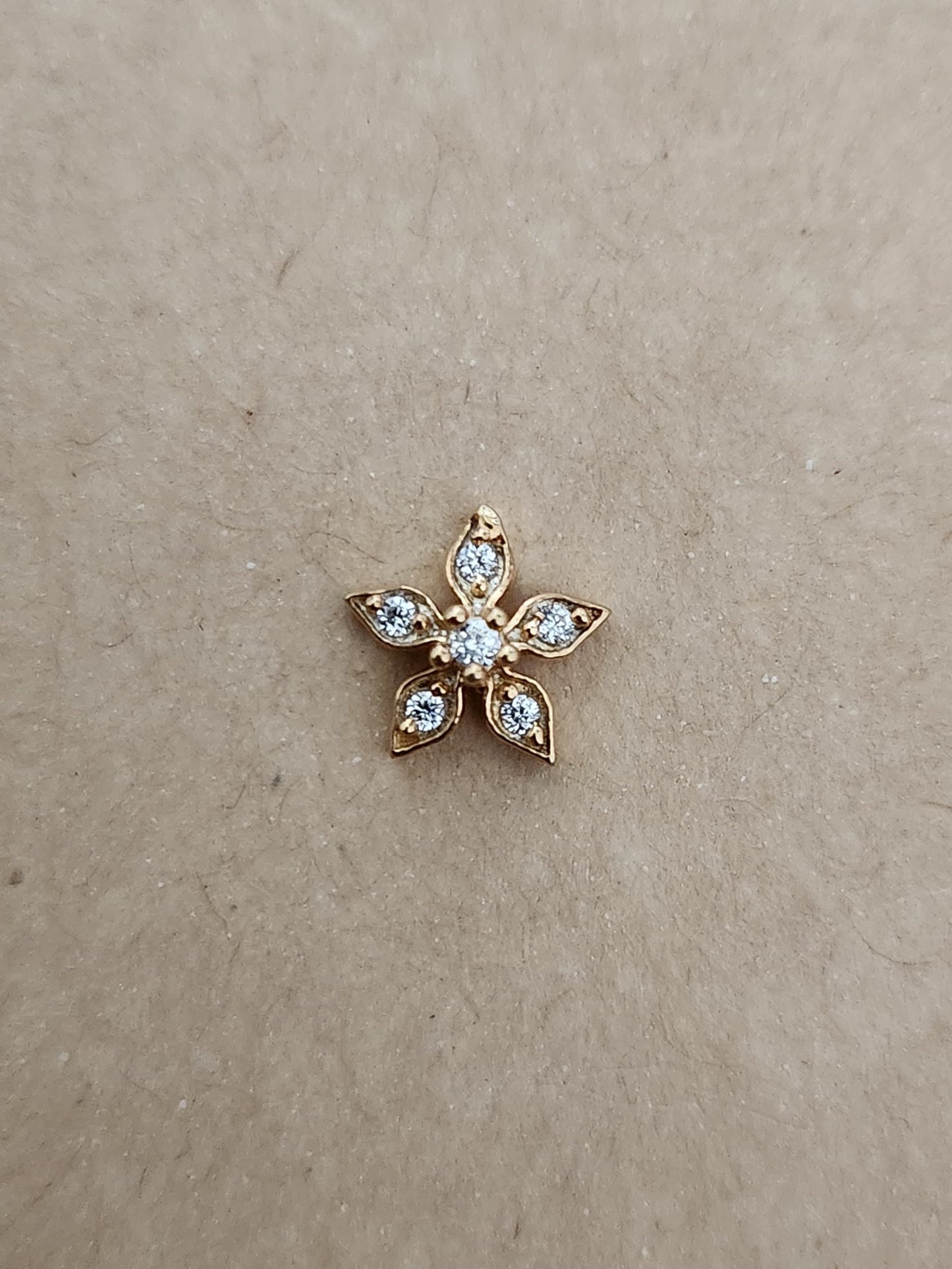 Silver nosepins featuring traditional motifs with a modern design twist, displayed on a neutral background.