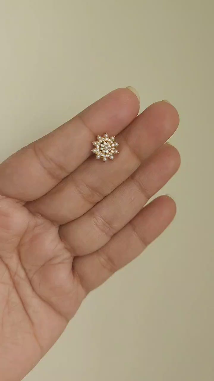 Silver nosepins featuring traditional motifs with a modern design twist, displayed on a neutral background.