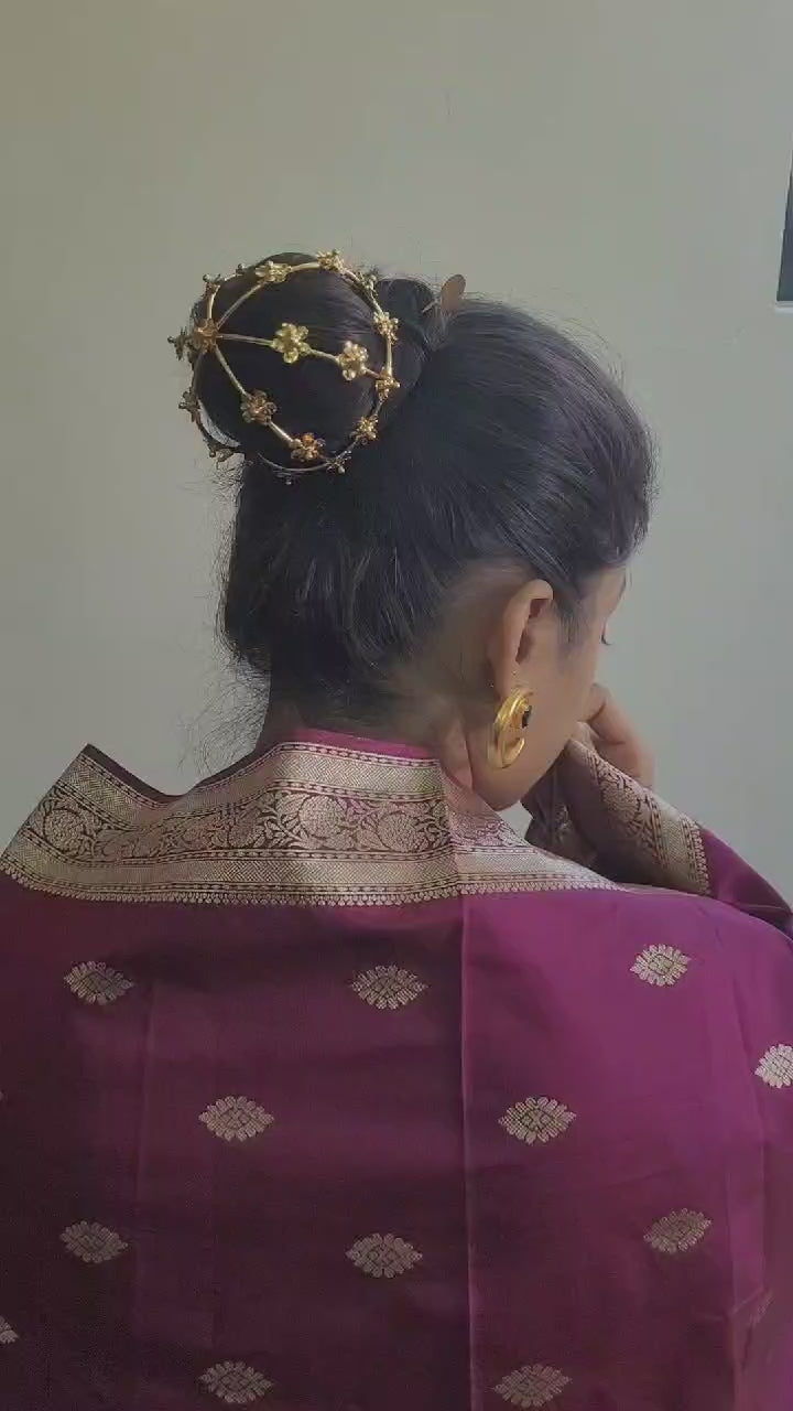 Gold spiral hairbun with concentric circles and intricate design. Elegant and artistic, it conveys a sense of sophistication.