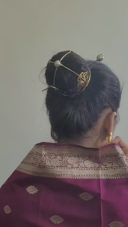 Gold spiral hairbun with concentric circles and intricate design. Elegant and artistic, it conveys a sense of sophistication.